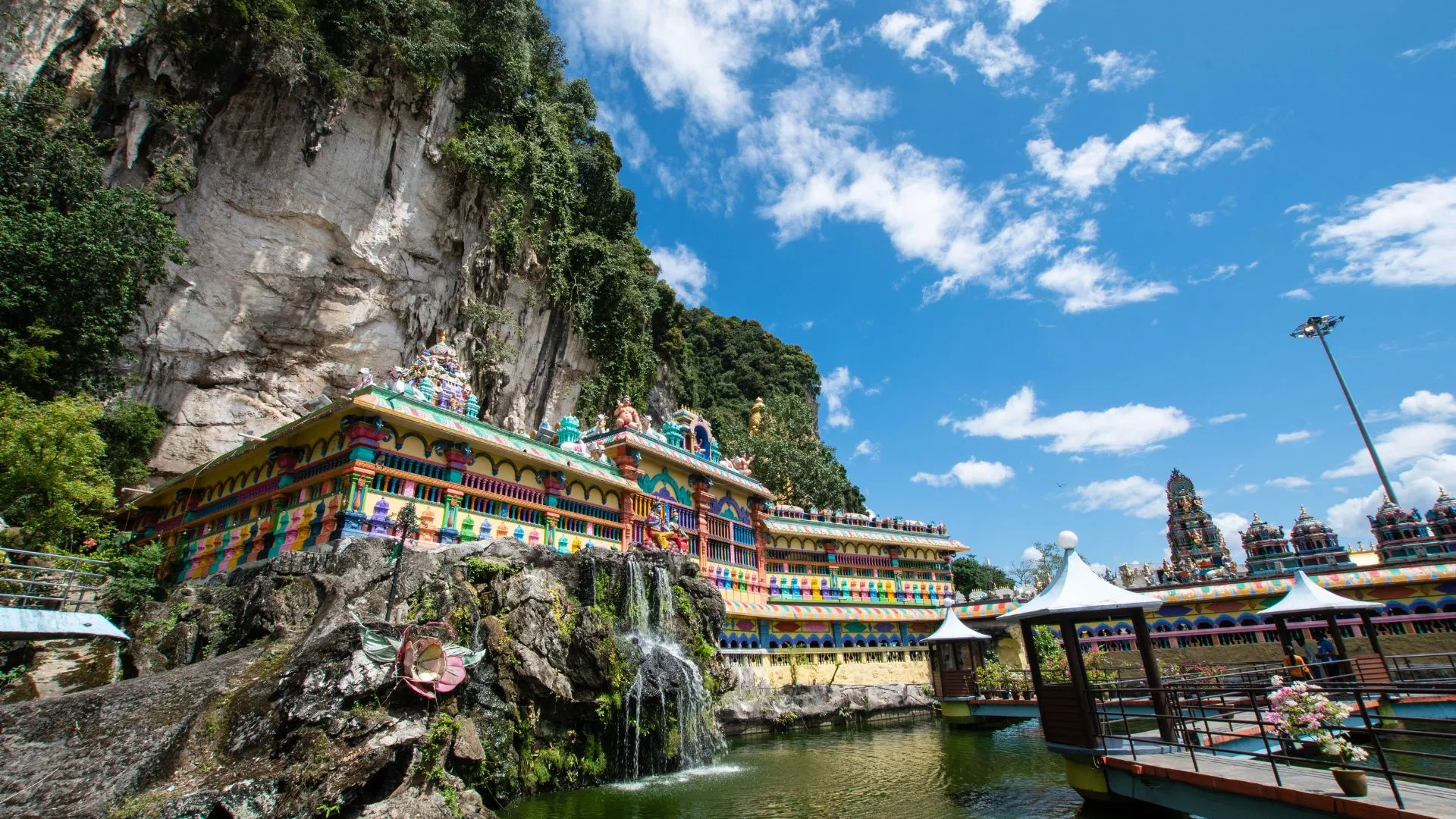 The painted galleries of Cave Villa at Batu Caves above the pond, below the limestone cliff