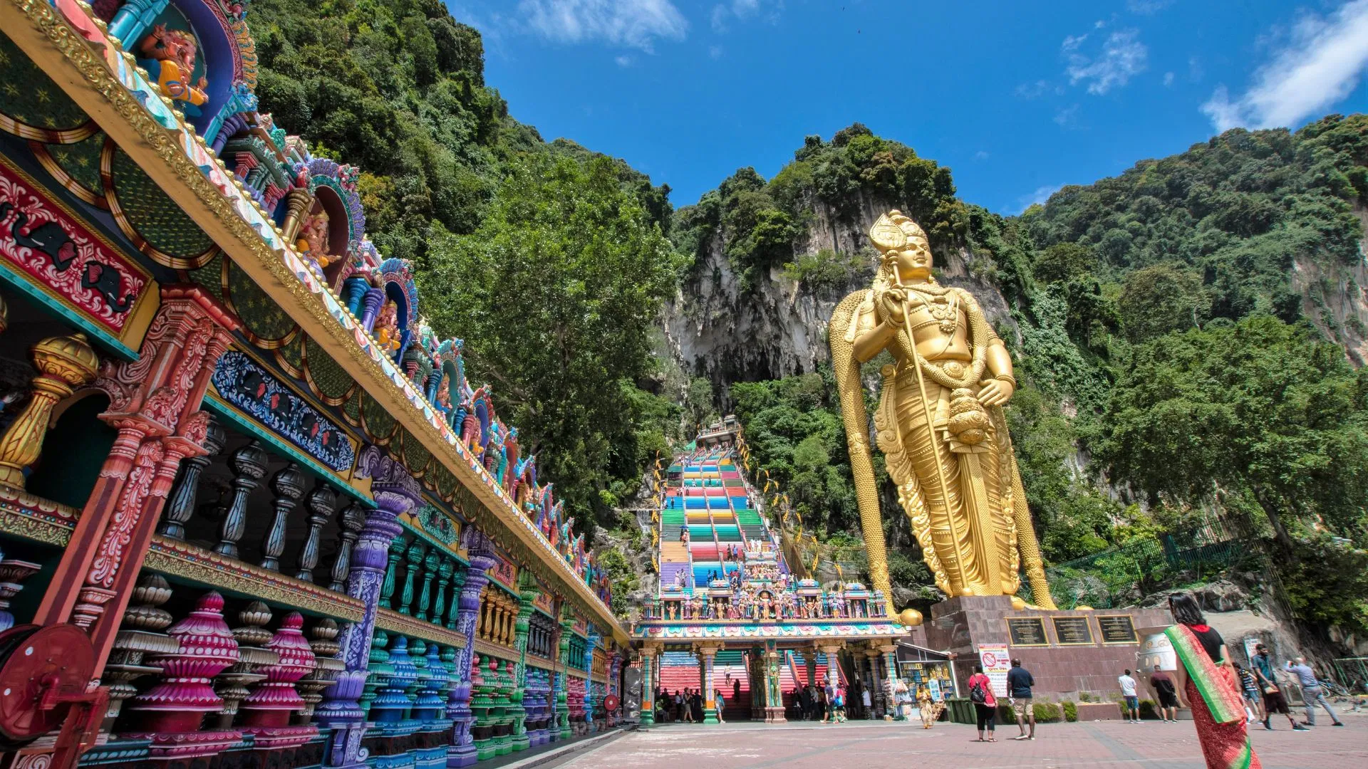 The golden Lord Murugan statue standing at the foot of the Batu Caves staircase