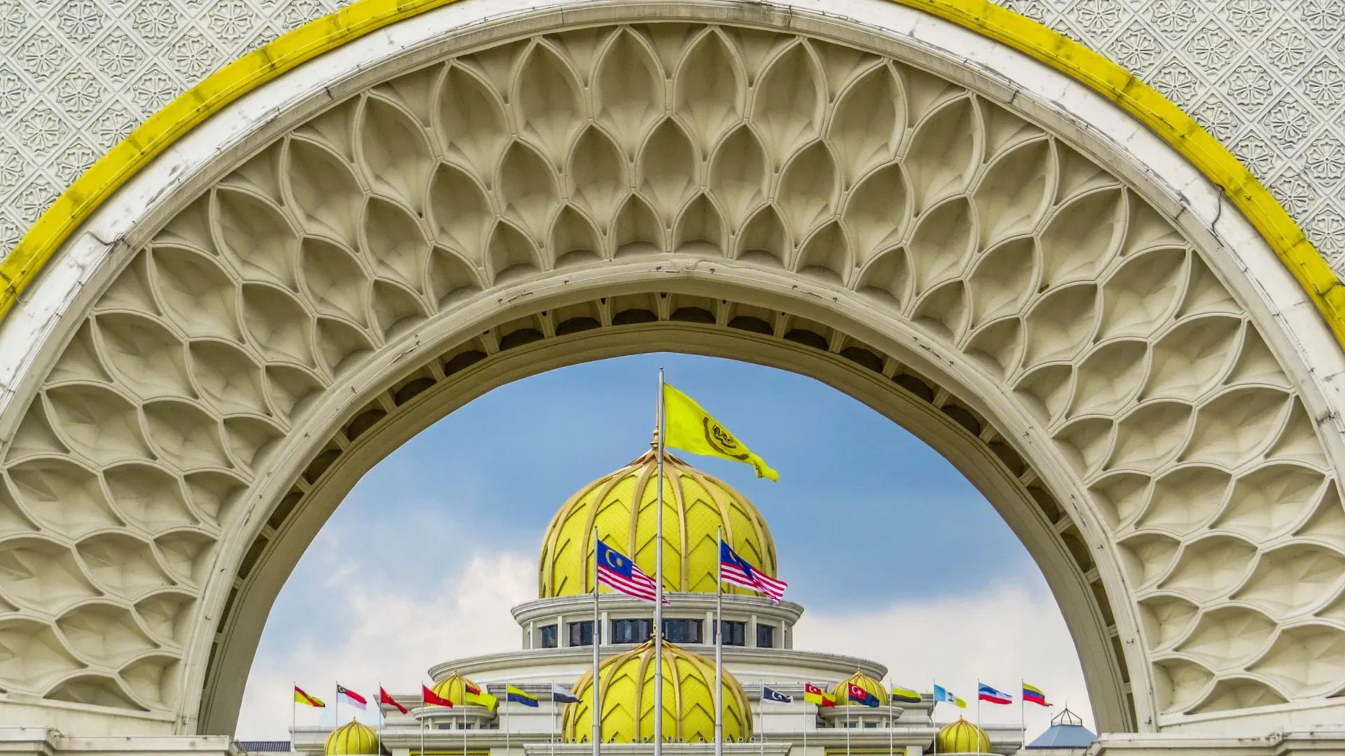 The golden domes of Istana Negara seen through the ceremonial arch