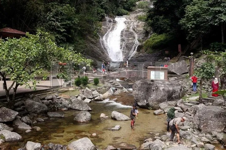 Visitors standing in the shallow stream below the Kanching waterfall in Gombak