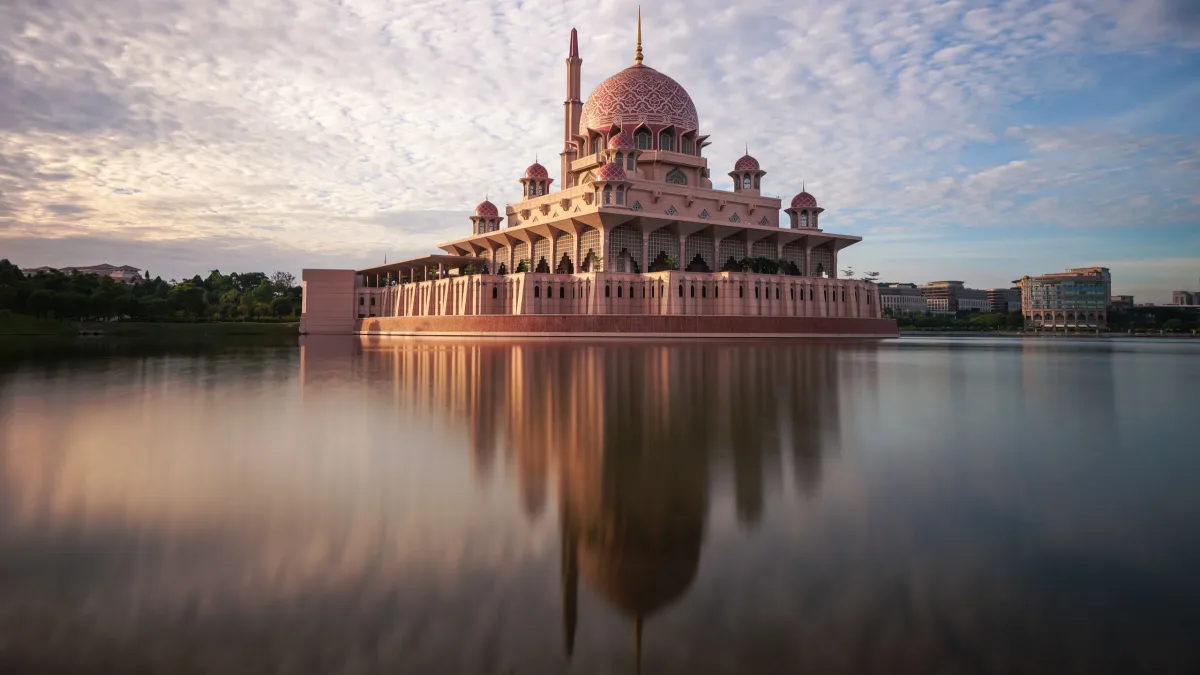 The pink Putra Mosque reflected in Putrajaya Lake at golden hour