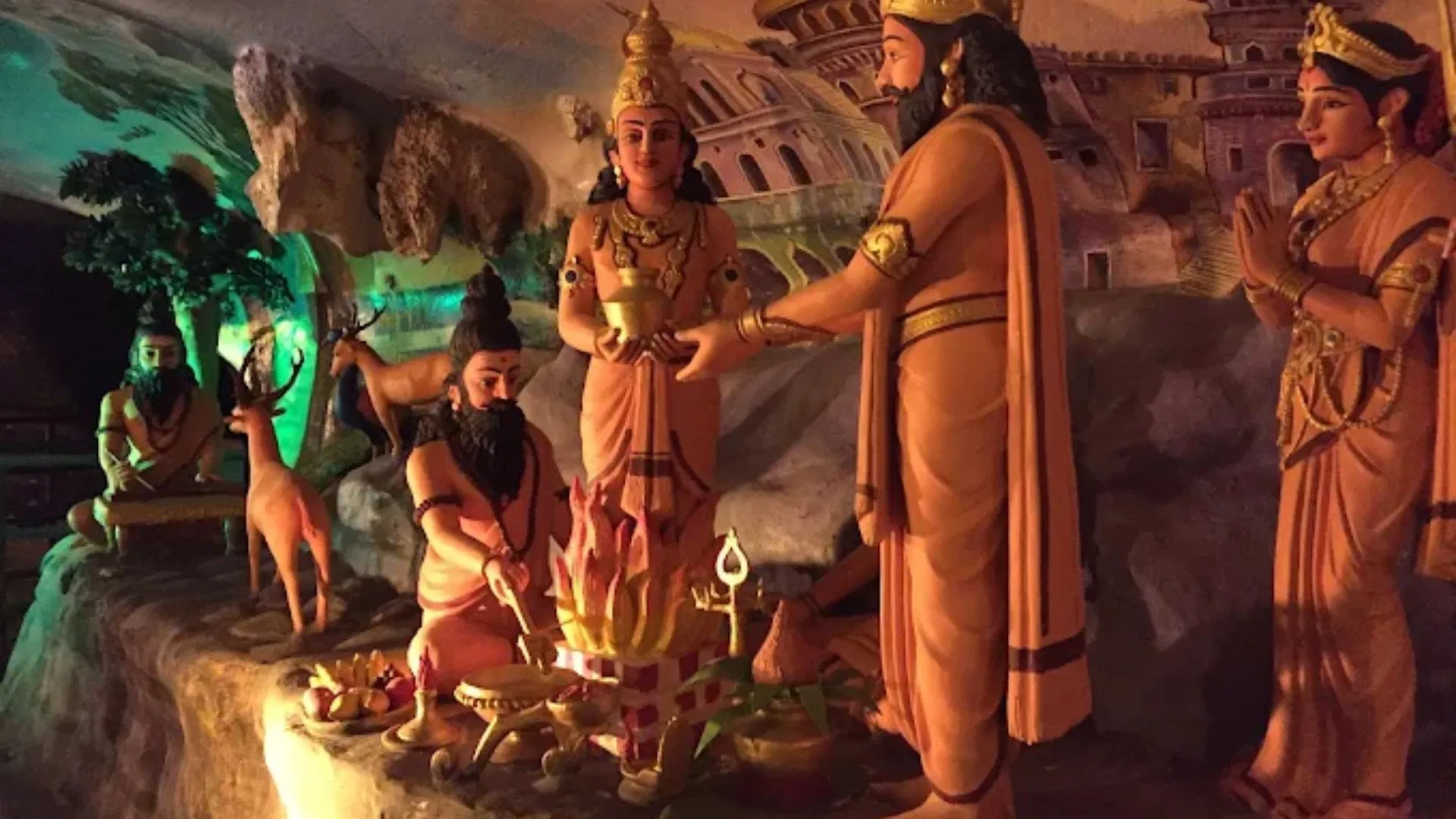 A painted Ramayana diorama inside Ramayana Cave, showing a sage at a fire ritual